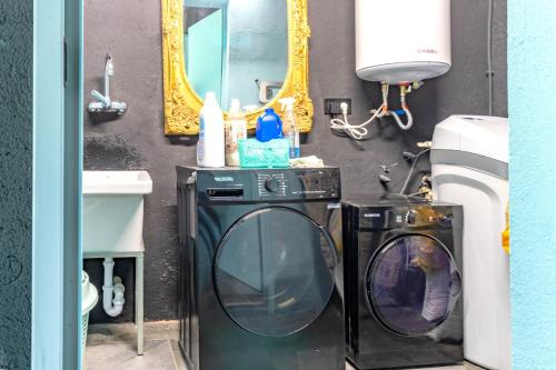 a bathroom with a washing machine and a mirror at Black House- Sorprendente casa estilo industrial in Olot