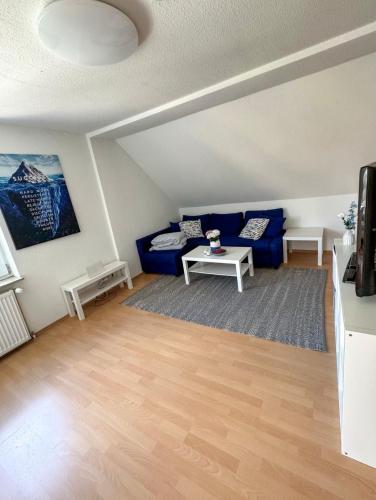 a living room with a blue couch and a table at Entspannungs Oase in Striegistal