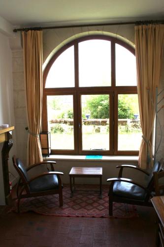 a room with two chairs and a large window at Charmant gite en rez-de-jardin in Saint-Aignan