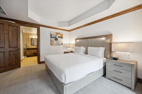 a bedroom with a large white bed and a wooden cabinet at The Aspen Mountain Residences in Aspen