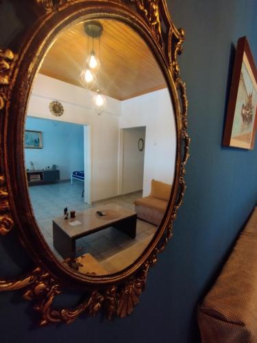 a mirror reflecting a living room with a couch and a table at HARBOR house in Kavála