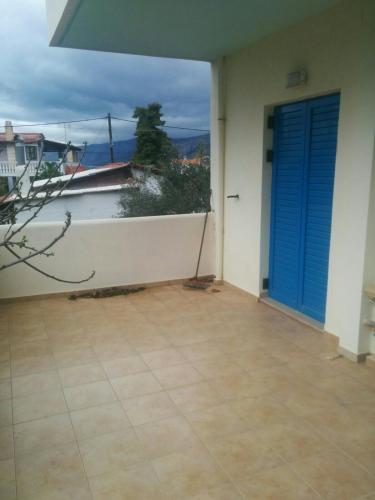 a balcony with a blue door and a view of the ocean at Angel in Káto Alepokhórion