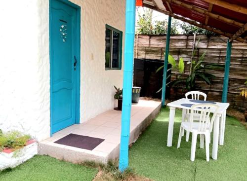 a patio with a table and chairs and a blue door at Portón Azul in Montañita