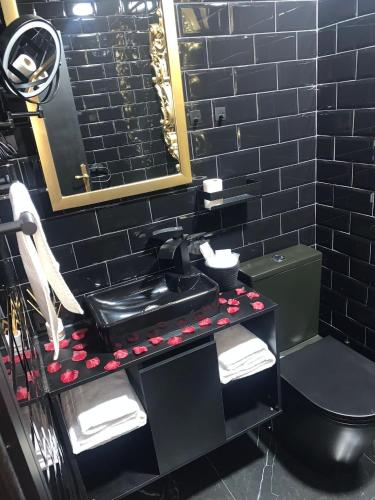 a black bathroom with a sink and a toilet at NUESTRA SEÑORA DEL PINAR in Galve de Sorbe
