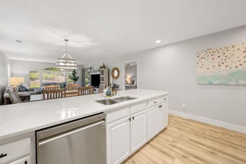 a kitchen with a sink and a living room at 55A 4th Hole Retreat at True Blue condo by Peace Vacations in Pawleys Island