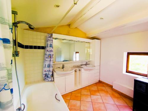 La salle de bains est pourvue d'une douche, de 2 lavabos et d'une baignoire. dans l'établissement Domaine Provençal 
