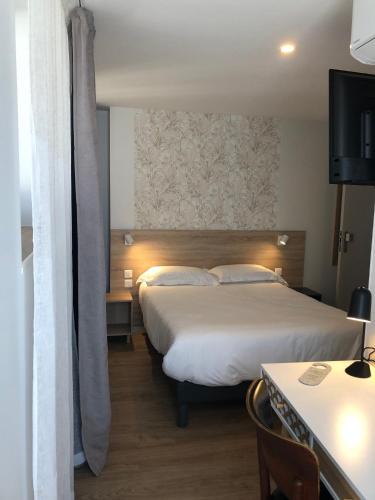 a hotel room with two beds and a table at Hôtel Océan Dinan in Dinan