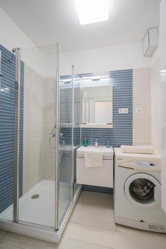 a bathroom with a washing machine and a washer at Blue Apartman Szántód in Szántód