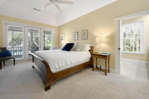 a bedroom with a bed and a chair and windows at Shearwater home by Peace Vacations in Georgetown