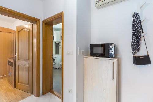 a room with a television on top of a refrigerator at Apartments Bellissima in Funtana