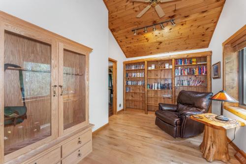 a living room with a leather chair and book shelves at Smeagles Terrapin in Arbor Vitae WI in Boulder Junction