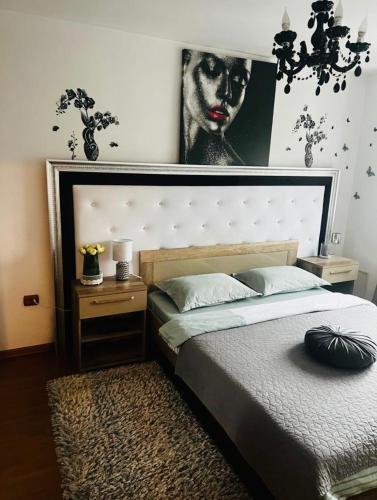 a bedroom with a bed and a picture of a woman at Apartament Lux Crialy - 75 m2 - free parking in Timişoara