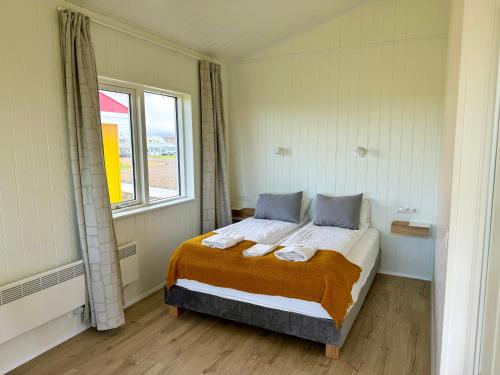 a bedroom with a bed in a room with a window at Hótel Lækur in Hella