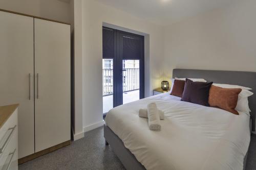 a bedroom with a large white bed with a mirror at Fantastic 2 Bedroom Apartment in Central Ashford in Ashford