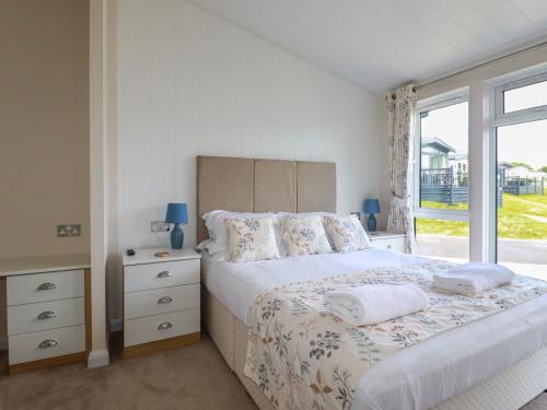 a bedroom with a large bed and a window at 43 The Maples in St Austell