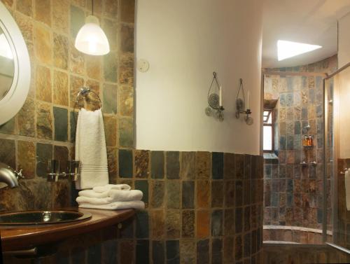 a bathroom with a sink and a shower at Isandlwana Lodge in Hlazakazi