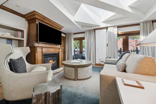 a living room with a fireplace and a tv at The Aspen Mountain Residences in Aspen