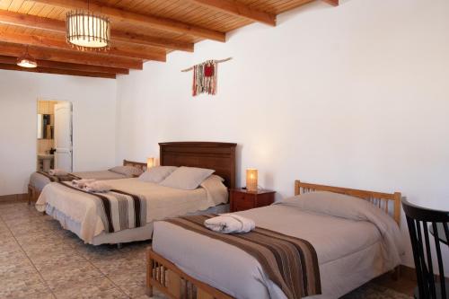 1 Schlafzimmer mit 3 Betten in einem Zimmer in der Unterkunft Casa Lickana B&B in San Pedro de Atacama