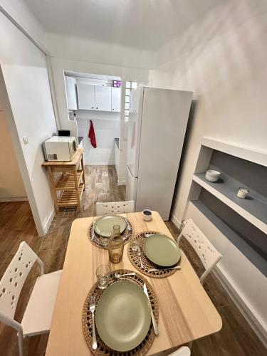 une cuisine avec une table, des chaises et un réfrigérateur dans l'établissement cassis studio 50m de la grande plage, à Cassis