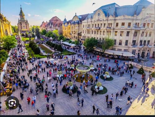 a group of people walking around a plaza in a city at Apartament Lux Crialy - 75 m2 - free parking in Timişoara