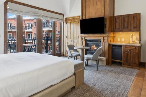 a bedroom with a bed and a kitchen with a fireplace at The Aspen Mountain Residences in Aspen