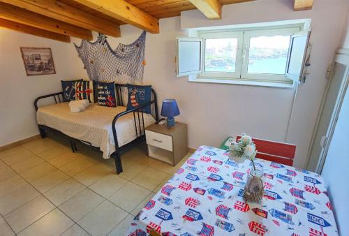 カターニアにあるLuxury Sisters House "Le Ancore"のベッドとテーブルと窓のある寝室