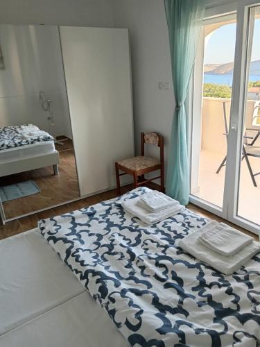 a bedroom with a bed and a window with a view at Apartmani Sol Vlašići in Pag
