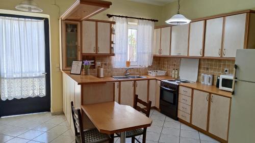 a kitchen with wooden cabinets and a table and a refrigerator at Veneta's House in Nerómilos