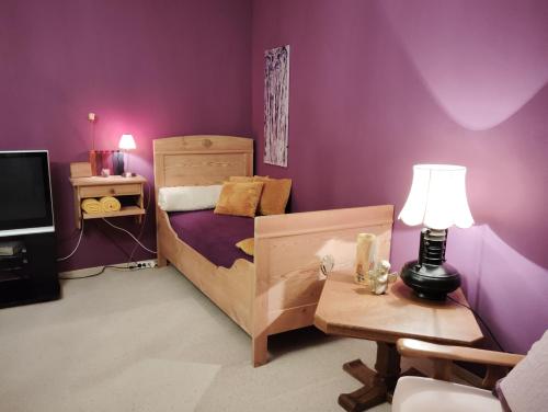 a bedroom with a bed and a table with a lamp at Apartments Angela in Wiesau