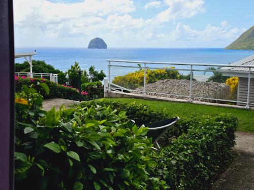 a view of the ocean from a garden at ALIZENZO in Le Diamant