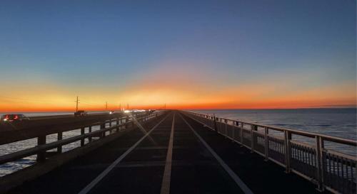 a bridge over the ocean with a sunset in the background at Free BBQ in RV With Private entrance in Homestead
