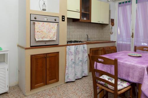a kitchen with a table with a purple table cloth at La Casa di Paola in Graffignano