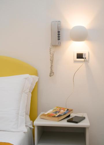 a phone on a wall next to a bed at Hotel St. Moritz in Rimini