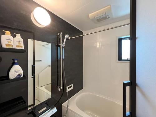 a bathroom with a shower and a white bath tub at Shibuya House-SY0108 in Tokyo
