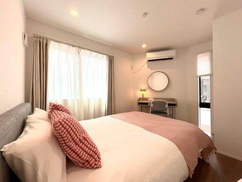 a bedroom with a bed with two pillows on it at Shibuya House-SY0108 in Tokyo
