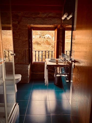 a bathroom with a sink and a toilet and a window at Casa Rural A Bouciña in Hio