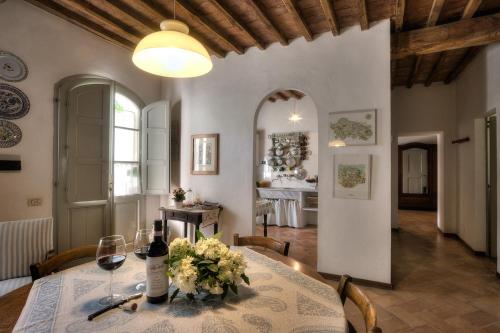 Un comedor con una mesa con una botella de vino. en allegretti appartamento aia, en Castelnuovo Berardenga