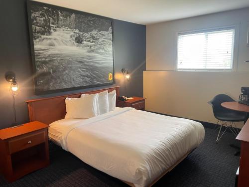 a hotel room with a bed and a desk at Super 8 by Wyndham Sainte Agathe Des Monts in Sainte-Agathe-des-Monts