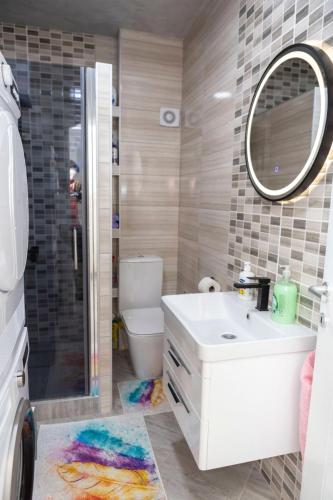 a bathroom with a toilet and a sink and a mirror at NelaLux in Podgradac