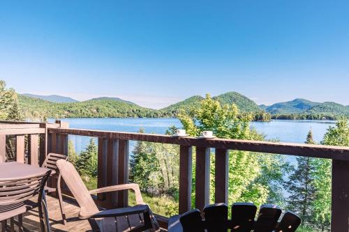 a balcony with chairs and a view of a lake at Lakefront, Mountain View - Resort Loft in Lac-Superieur
