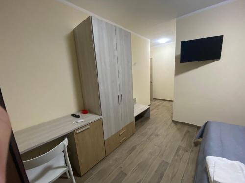 a room with a bed and a desk and a tv at Sogni d'insonnia in San Sosti