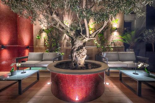 a large tree in a room with tables and benches at Hotel Raganelli in Rome