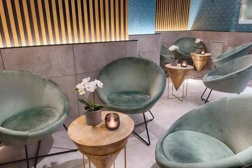 a waiting room with green chairs and a table with flowers at Hotel Raganelli in Rome