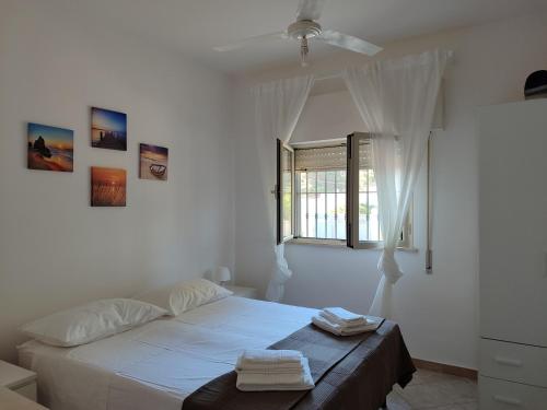 a white bedroom with a bed and a window at Villa d'Angela in San Pietro in Bevagna