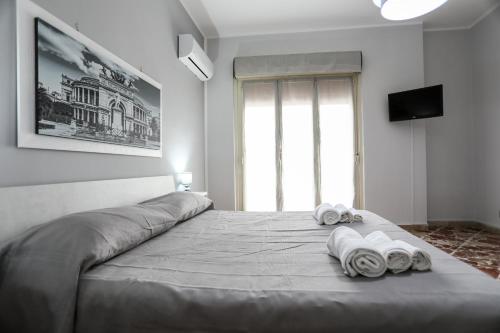 a bedroom with a large bed with towels on it at Medea Suite Panoramic in Palermo