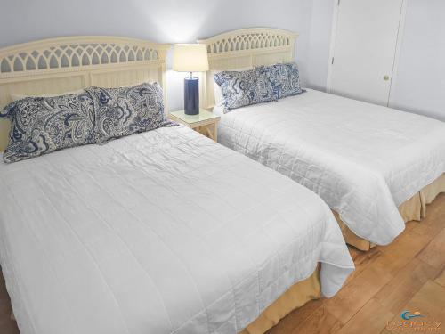 a bedroom with two beds and a table with a lamp at IS2 - Cozy 1 Bd - Steps Away From the Beach in Fort Walton Beach