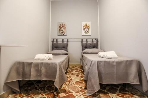 two beds in a room with tables with towels at Medea Suite Panoramic in Palermo