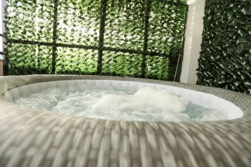 a tub filled with water in front of a window at Medea Suite Panoramic in Palermo