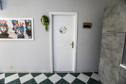 a white door in a bathroom with a tile floor at Medea Suite Panoramic in Palermo