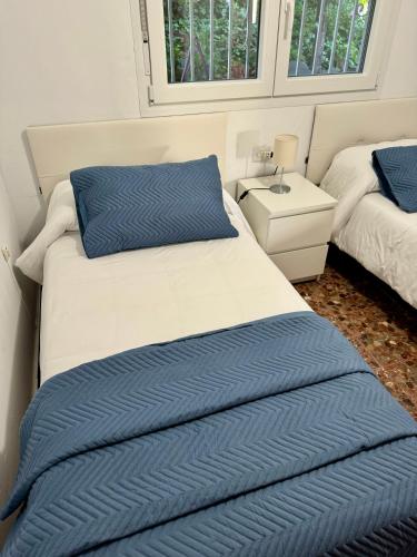 a bedroom with two beds with blue and white sheets at Casa rural Balcón de Monachil in Monachil